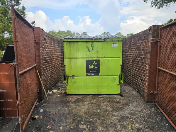 The same dumpster enclosure with the loose trash removed